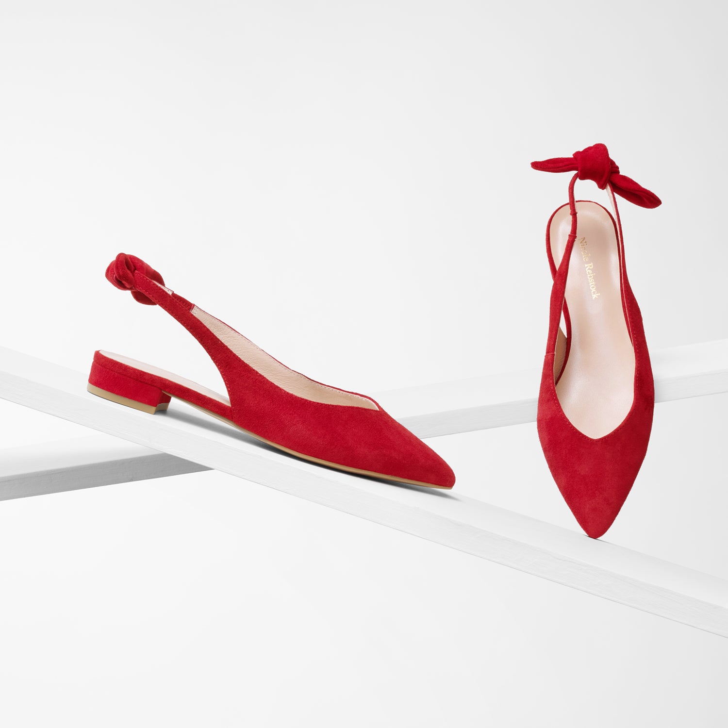 Vienna red suede sling back with pointed toe and bow on planks showing all angles.