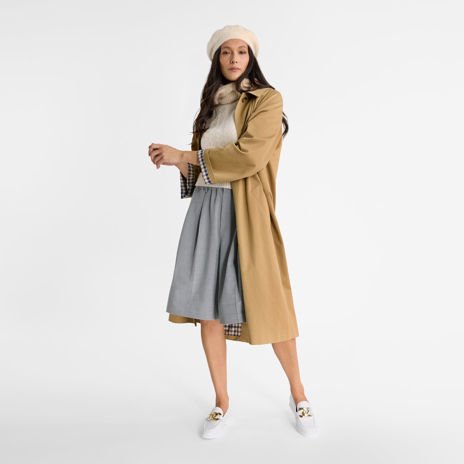 Woman wearing white loafers with gold accents with round toes and boat shoe soles