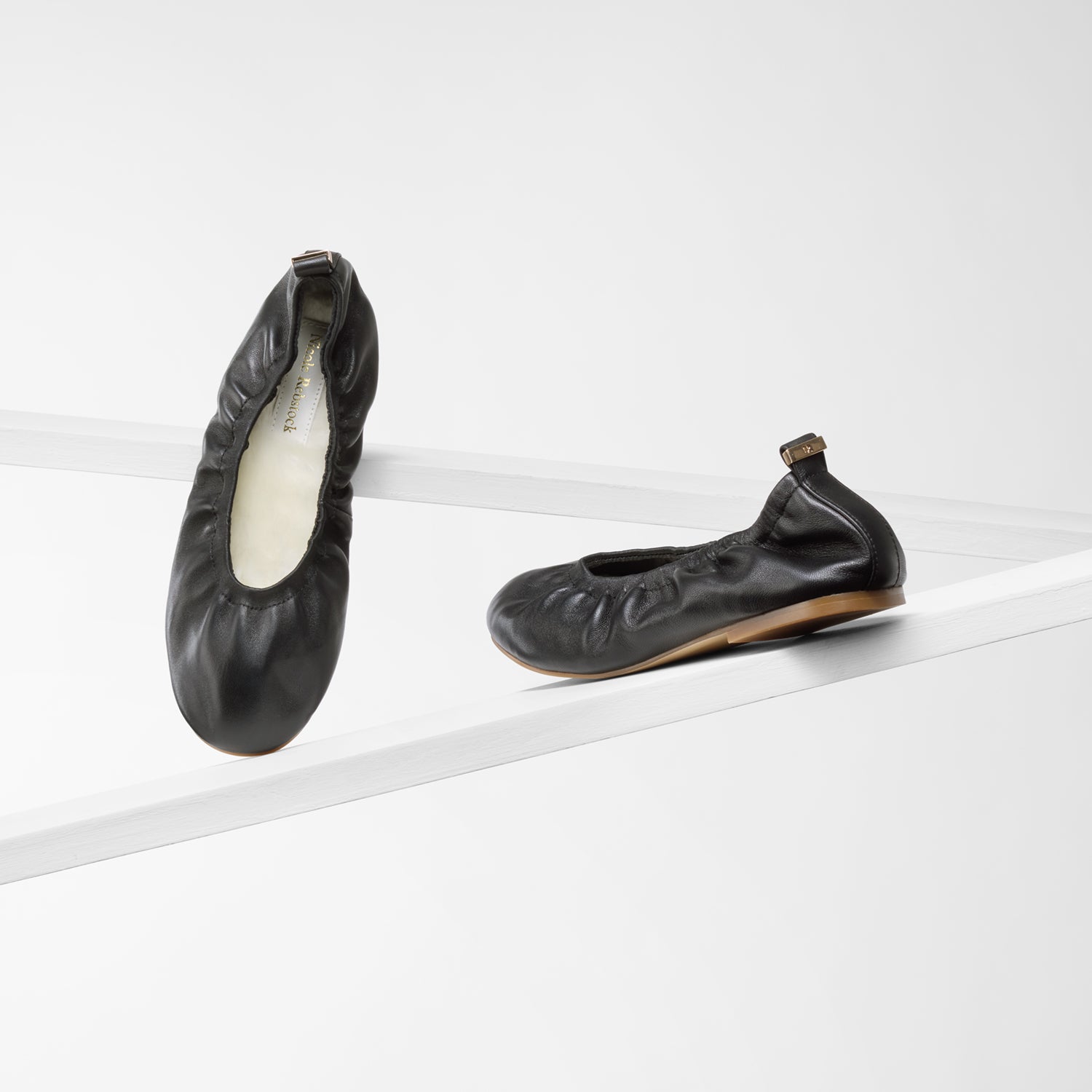 Xia black ballet flats with white woollen insoles.