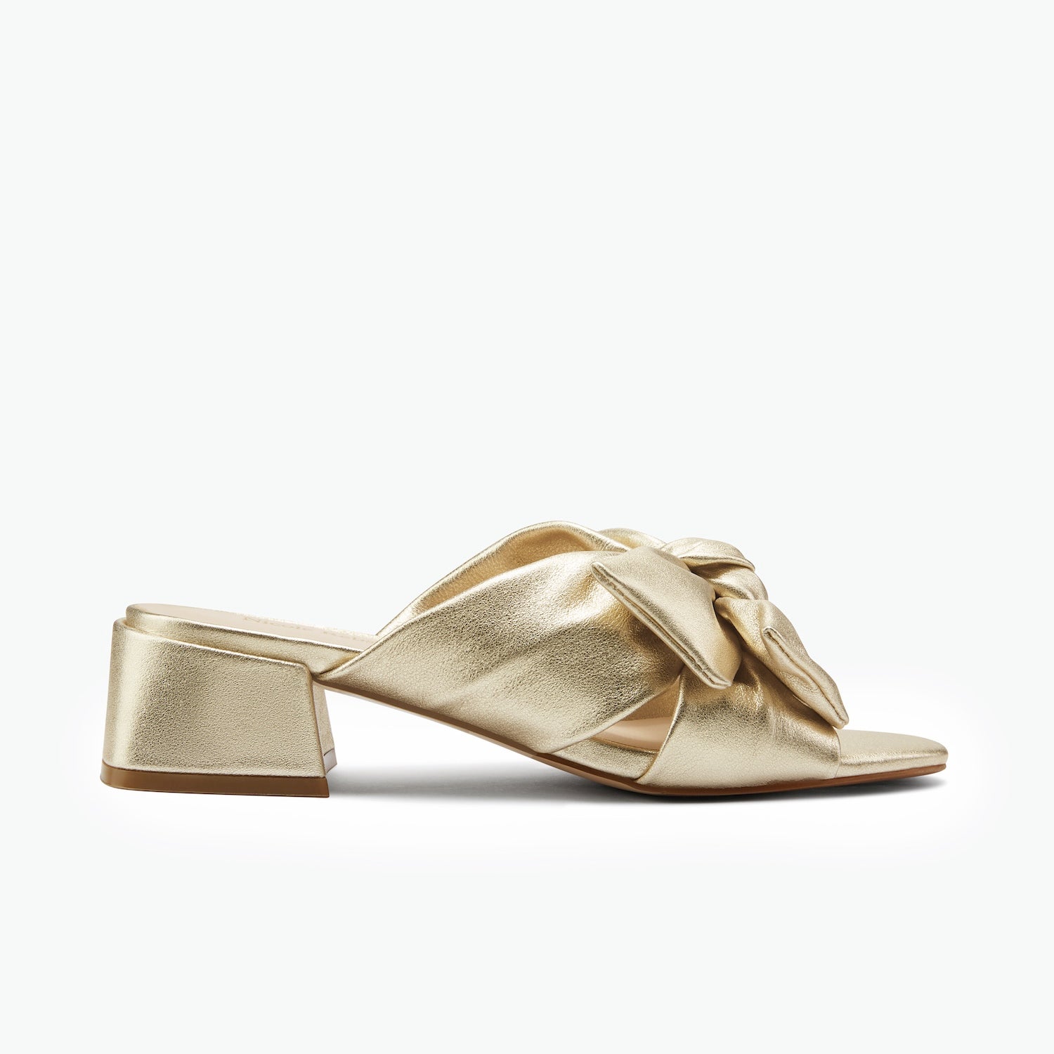 Gold leather slide sandal with bow.  Low block heel on white background.