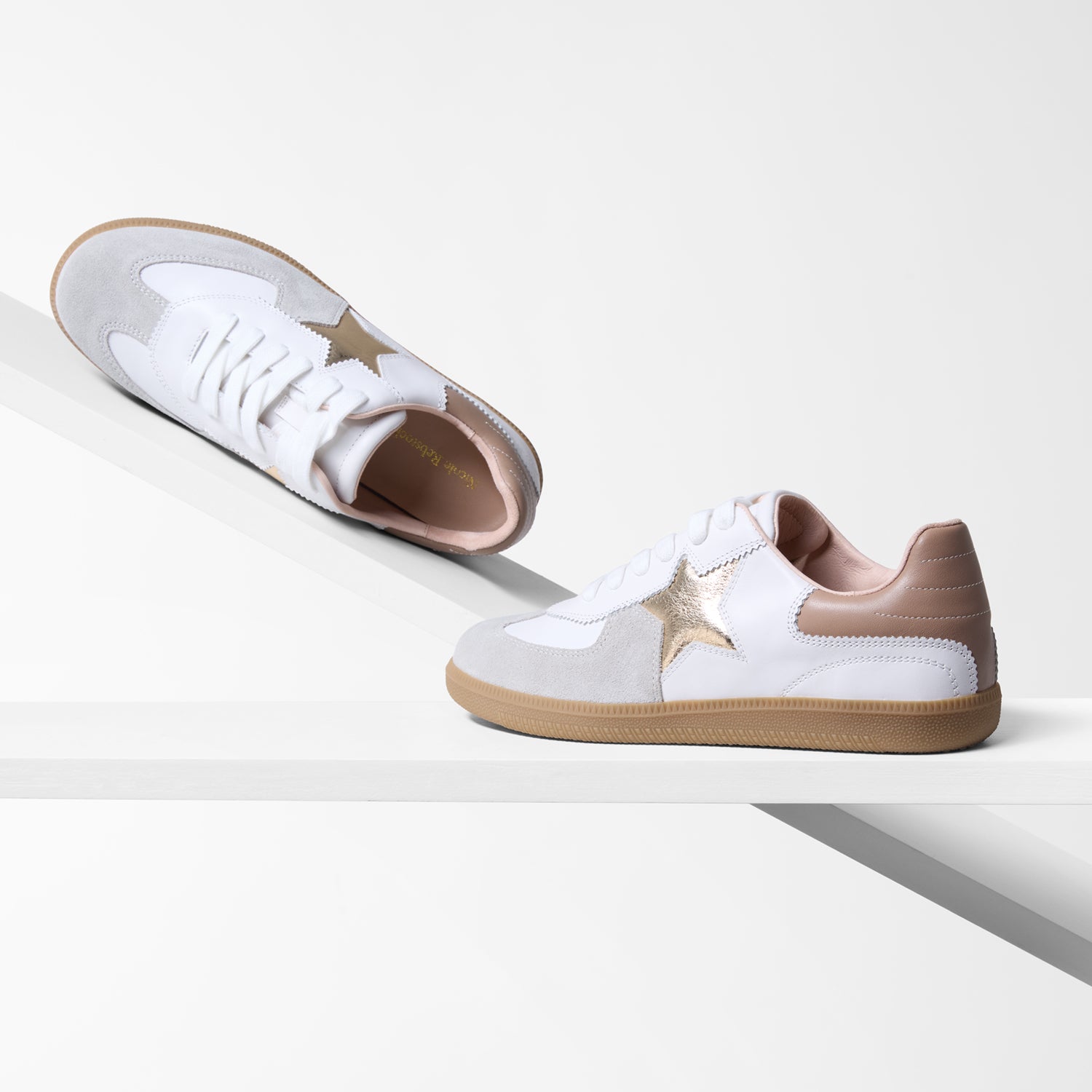 White sneakers with beige accents on a white background