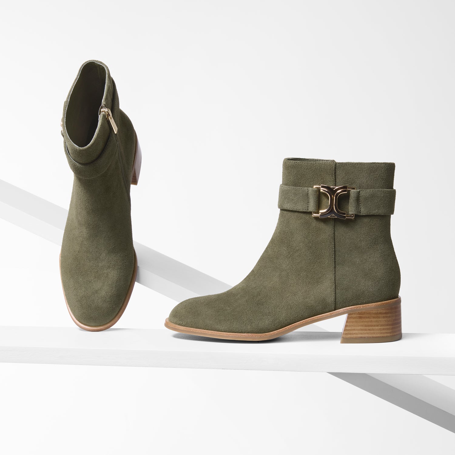 Pair of green suede ankle boots with a buckle on a white background. Round toe and 4.5cm heel.