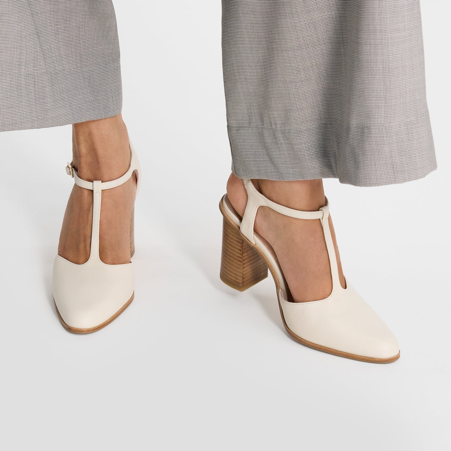 Ivory pumps with block heels worn by a women. 8cm heel. Almond toe.