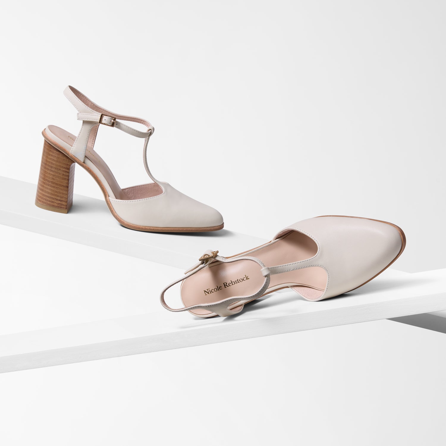 Pair of beige high-heeled shoes on a white background by Nicole Rebstock