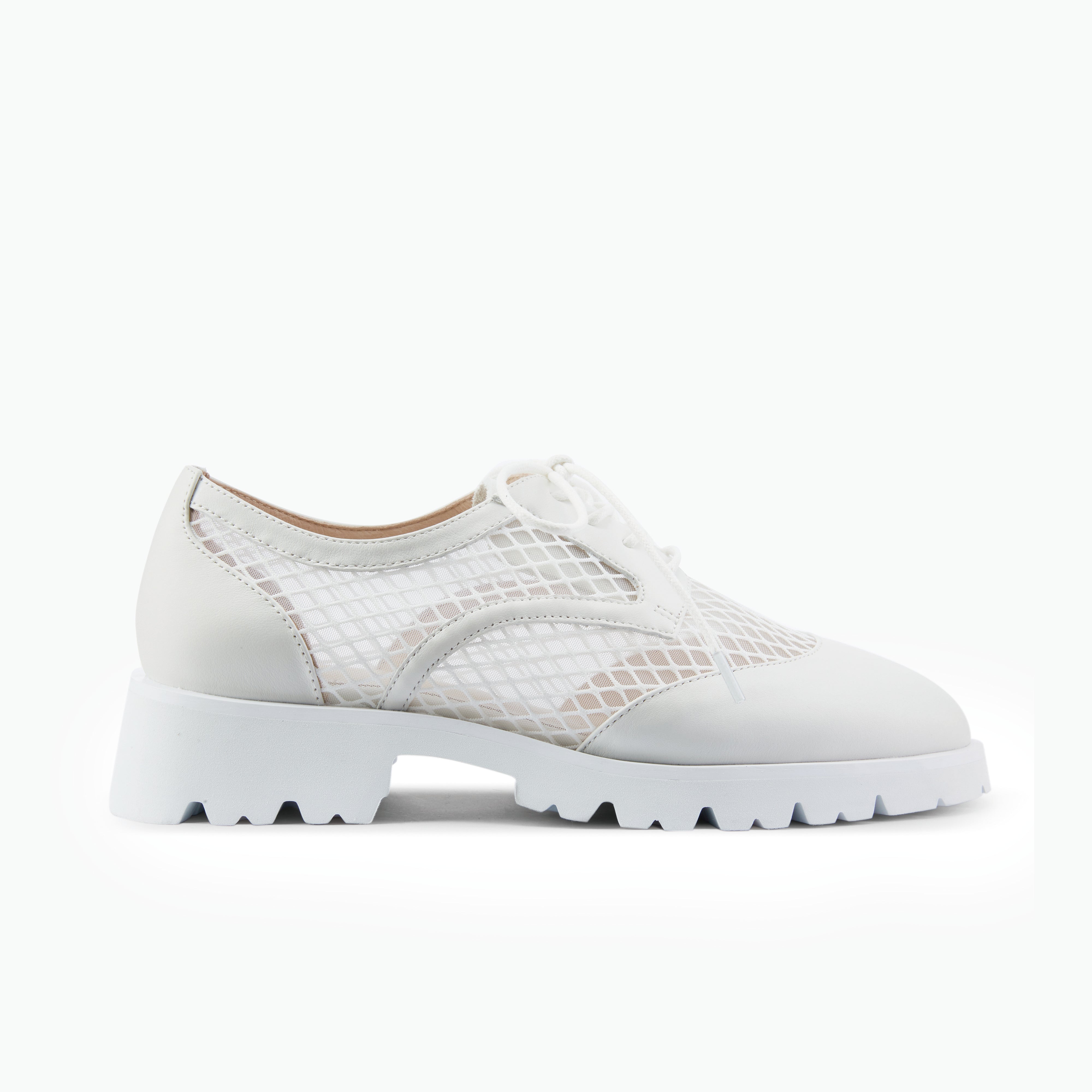 White oxford lace up made of leather and mesh on a chunky sole with an almond toe.