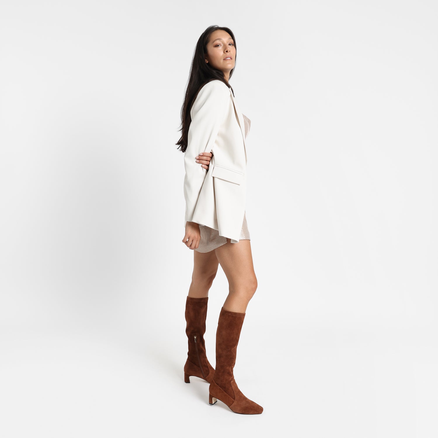 Woman wears limited edition dakota knee high boot in chestnut. Boot is stretchy and has a square and pointed toe. Heel height is 5.5cm.