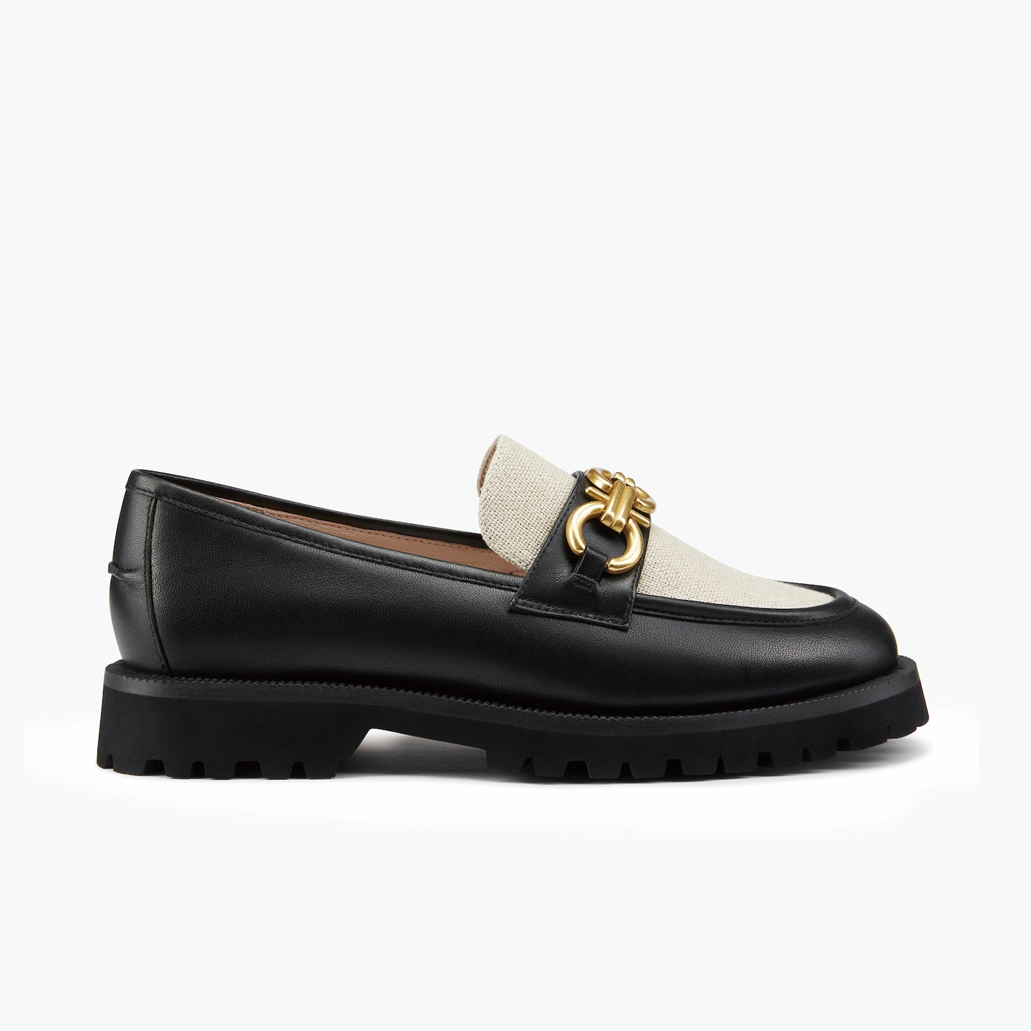 Black leather loafer with linen tongue and gold chain on a white background.
