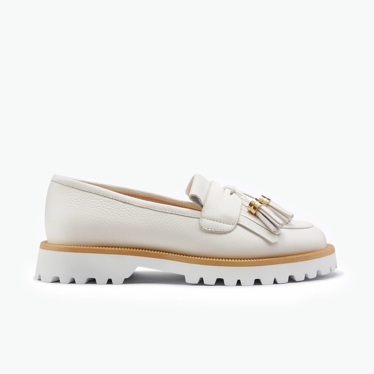 A single white leather loafer with a tassel detail and a chunky white lug sole, shown from a side profile on a clean white background.