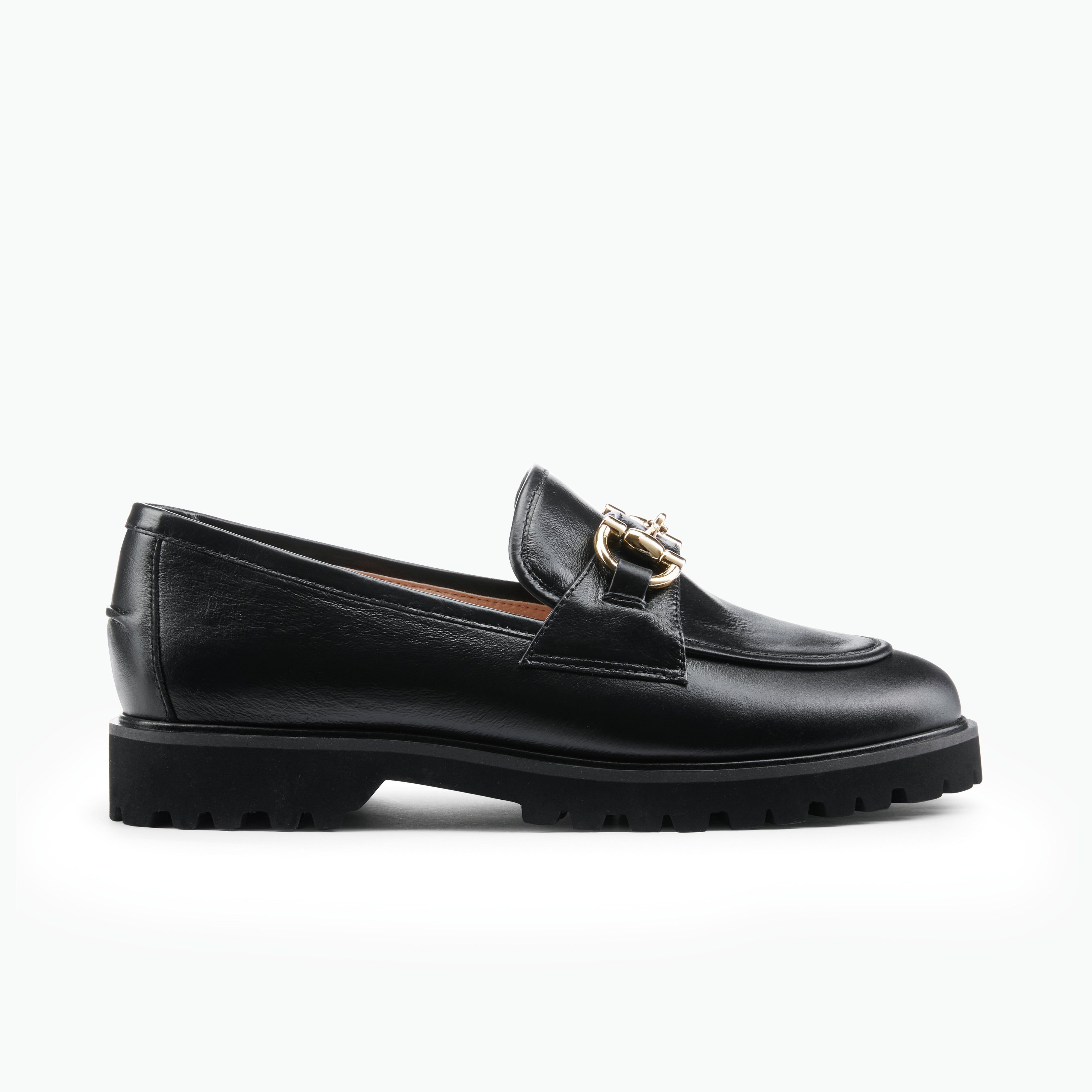 Black loafer shoe with gold buckle on a white background