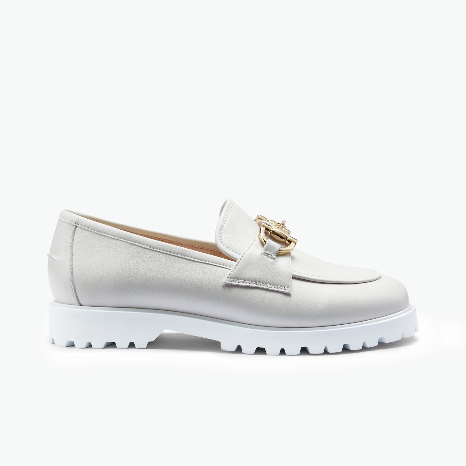 White loafer shoe with gold accents on a white background