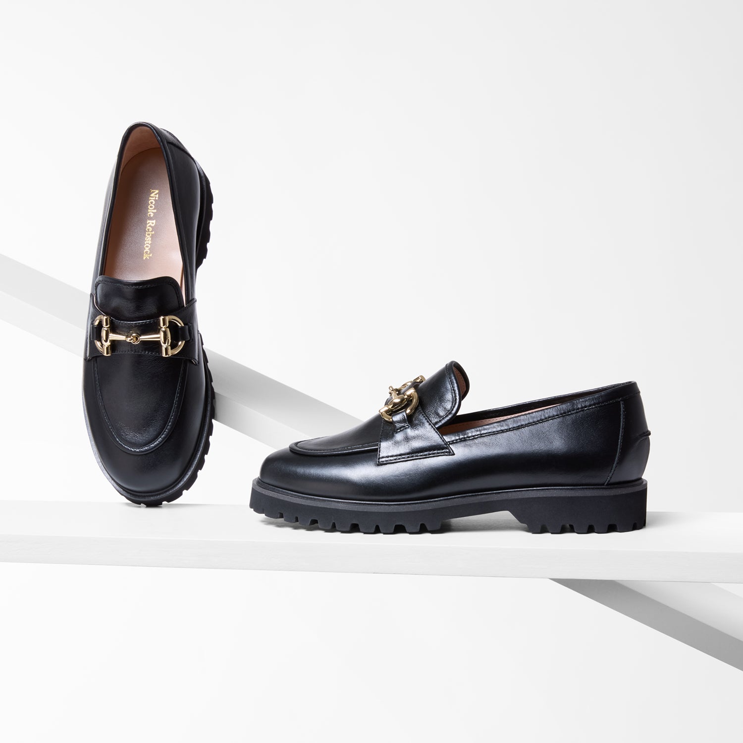 Black loafers with gold accents on a white background shown from various angles. 2.5cm heel. chunky sole.
