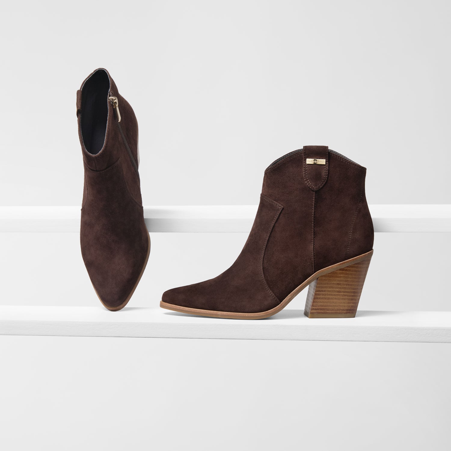 Pair of brown suede ankle boots on a white background