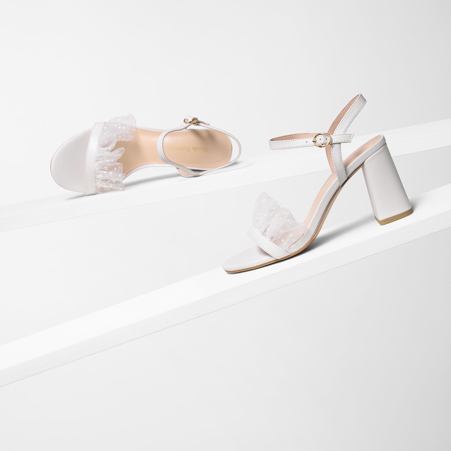 All angle view of Freya off-white sandals. Gold hardware buckles. 
