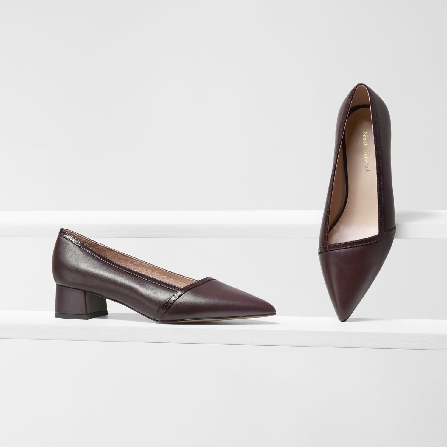 Pair of brown leather pumps with pointed toe and block heel.