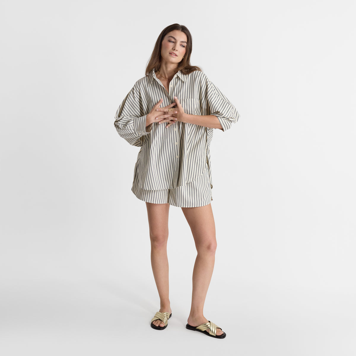 Model wearing Nicole Rebstock's gold Latta slide sandal.
