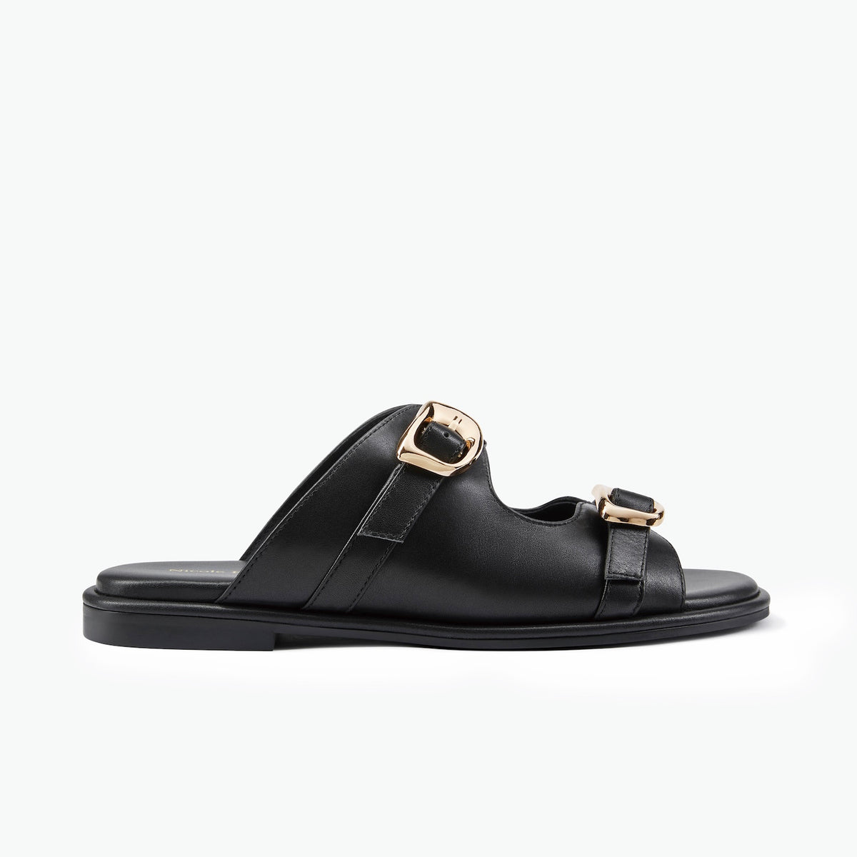 A single flat black leather slide sandal with two adjustable straps and gold-tone metal buckles, shown in profile against a plain white background.