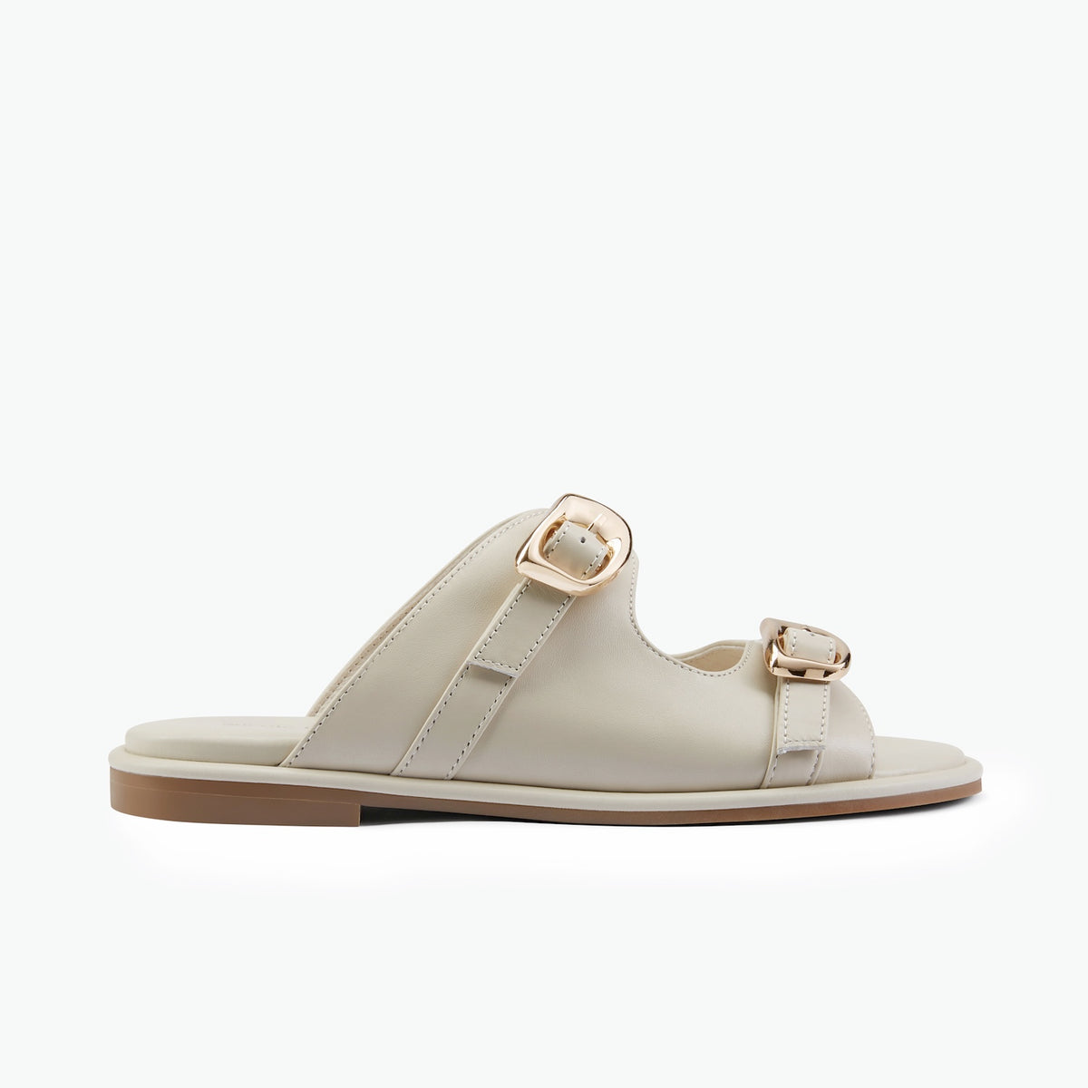 A single women's slide sandal in light beige leather with two adjustable straps and rose gold-tone buckles, shown in a side profile on a white background.