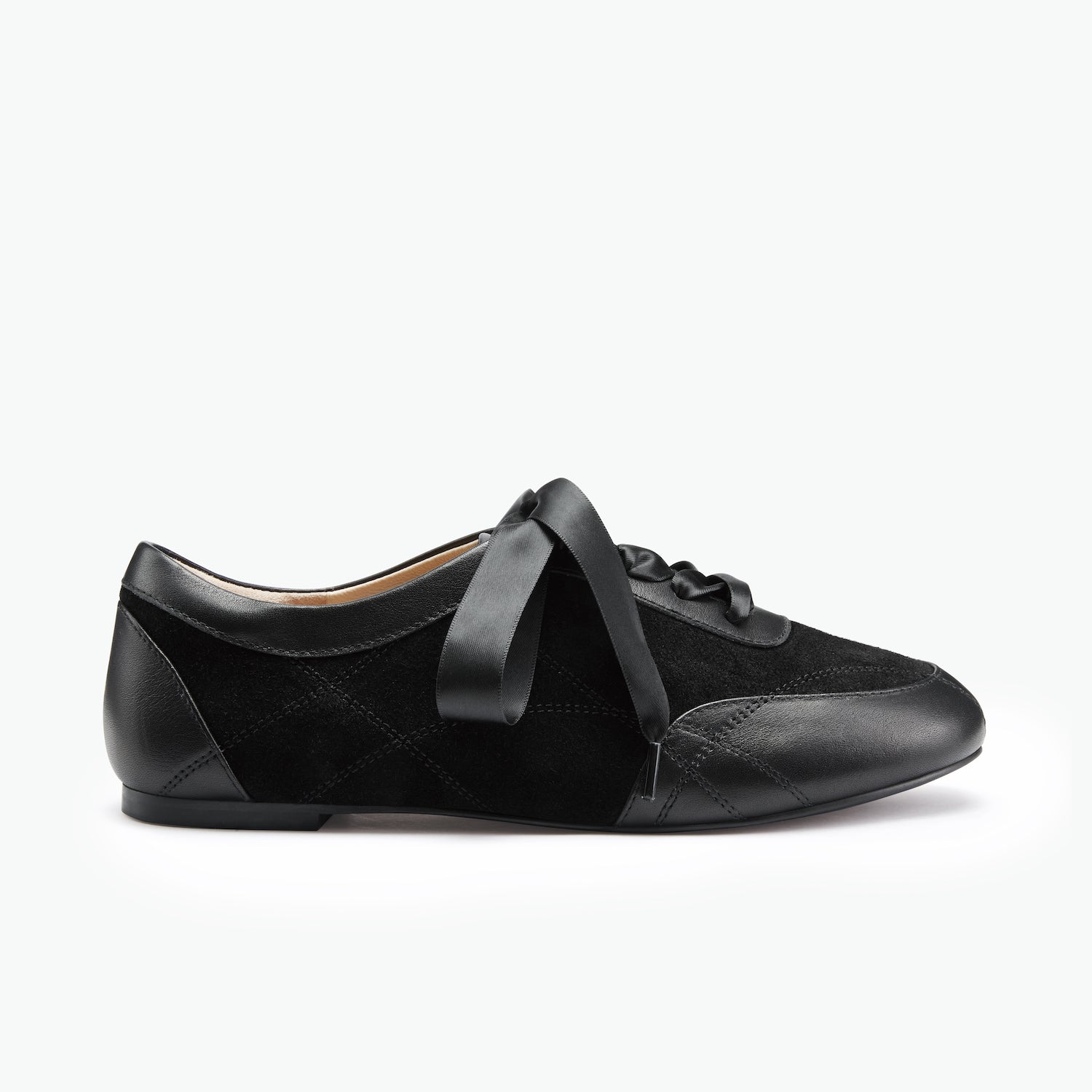 Black casual sneaker with ribbon laces on white background.