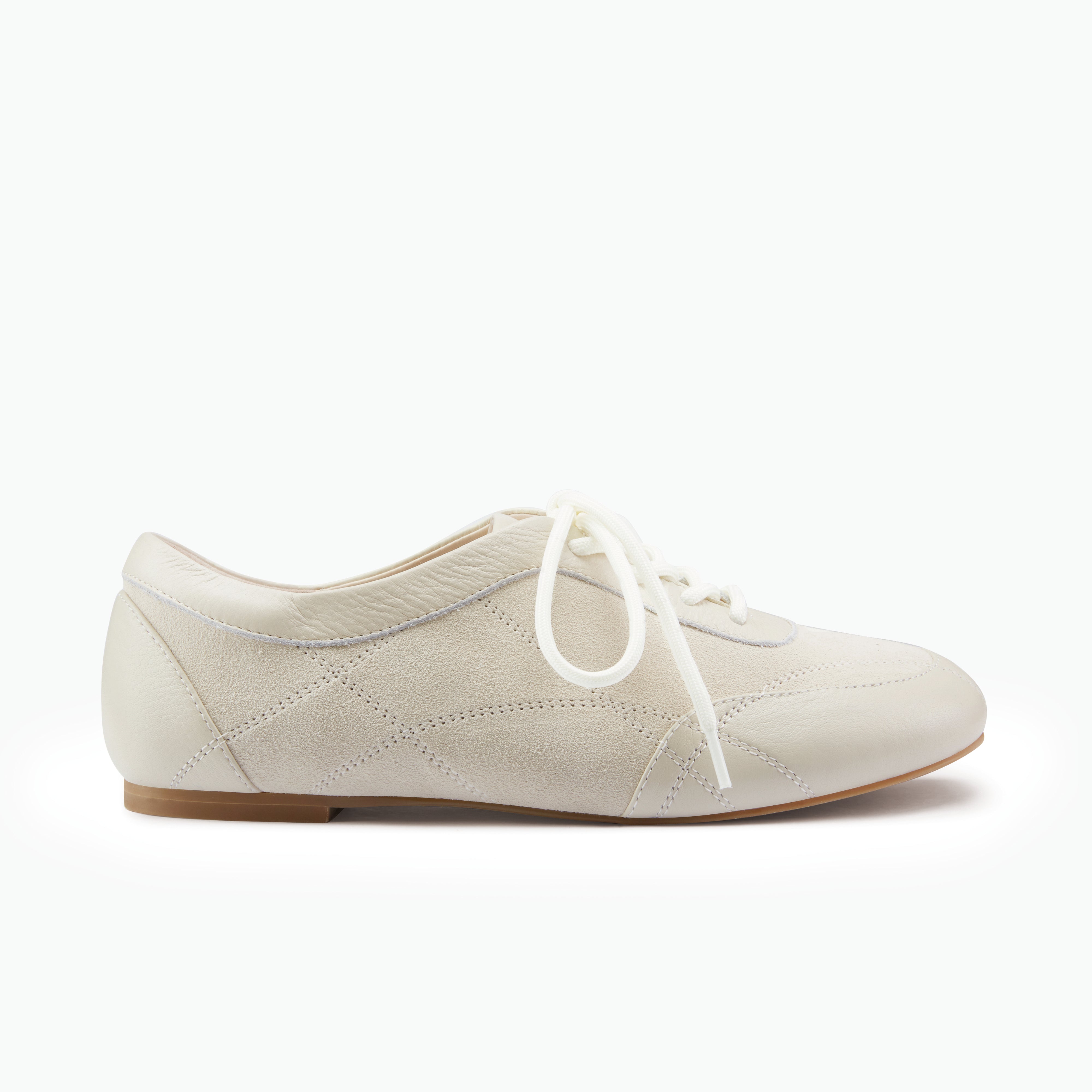 Sneakerinas in oat suede with white laces on a white background