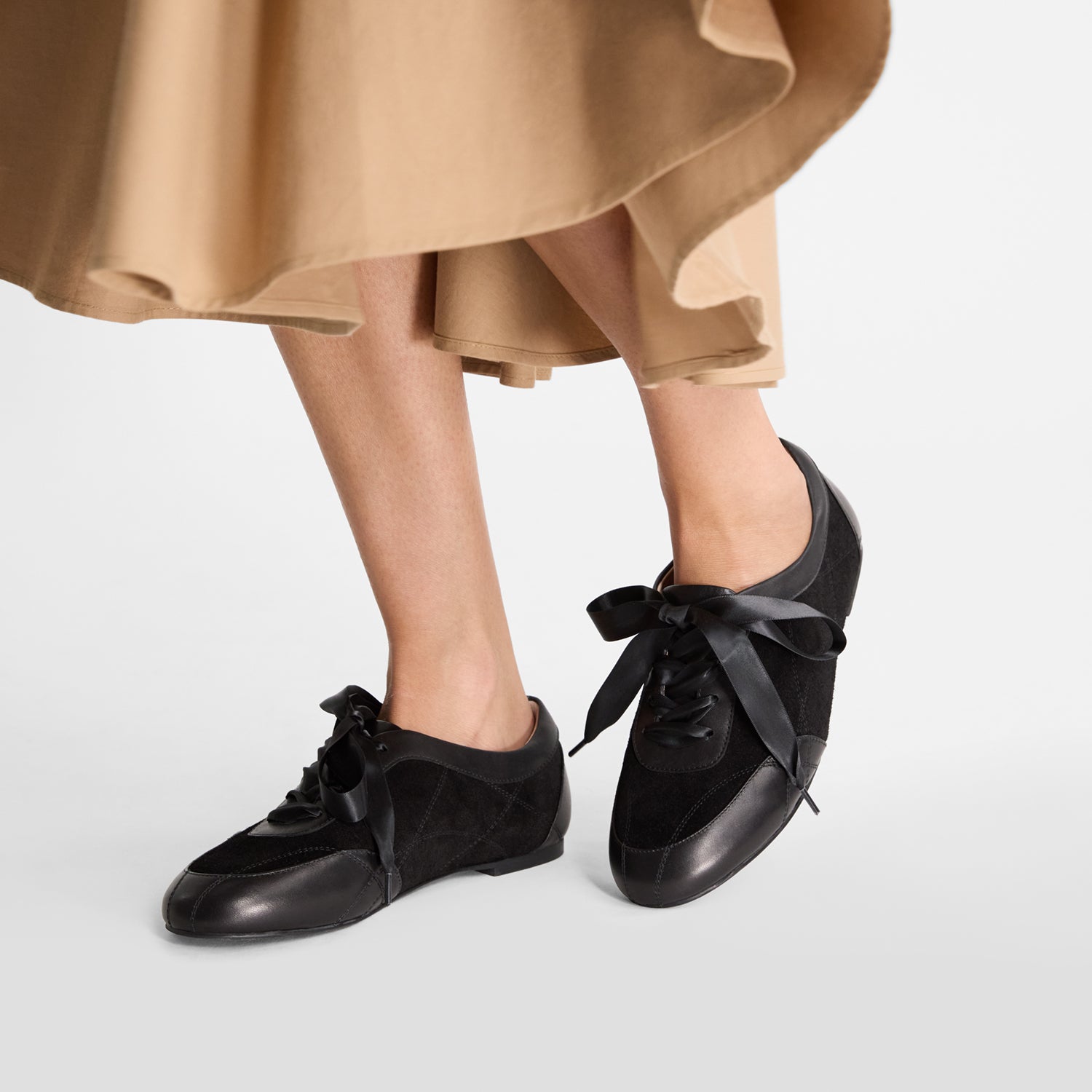 model wears Nicole Rebstock's round toe sneakers. Feminine in style. Leather and suede.