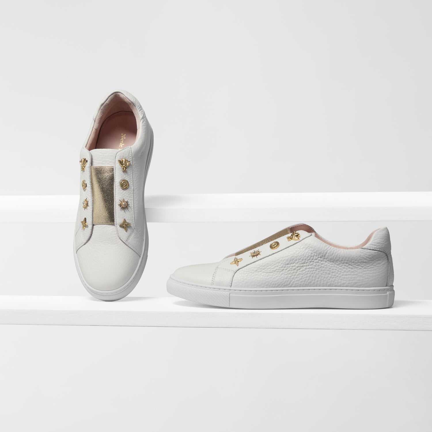 Off-white leather sneakers with gold elastic and gold studs, shown from various angles.