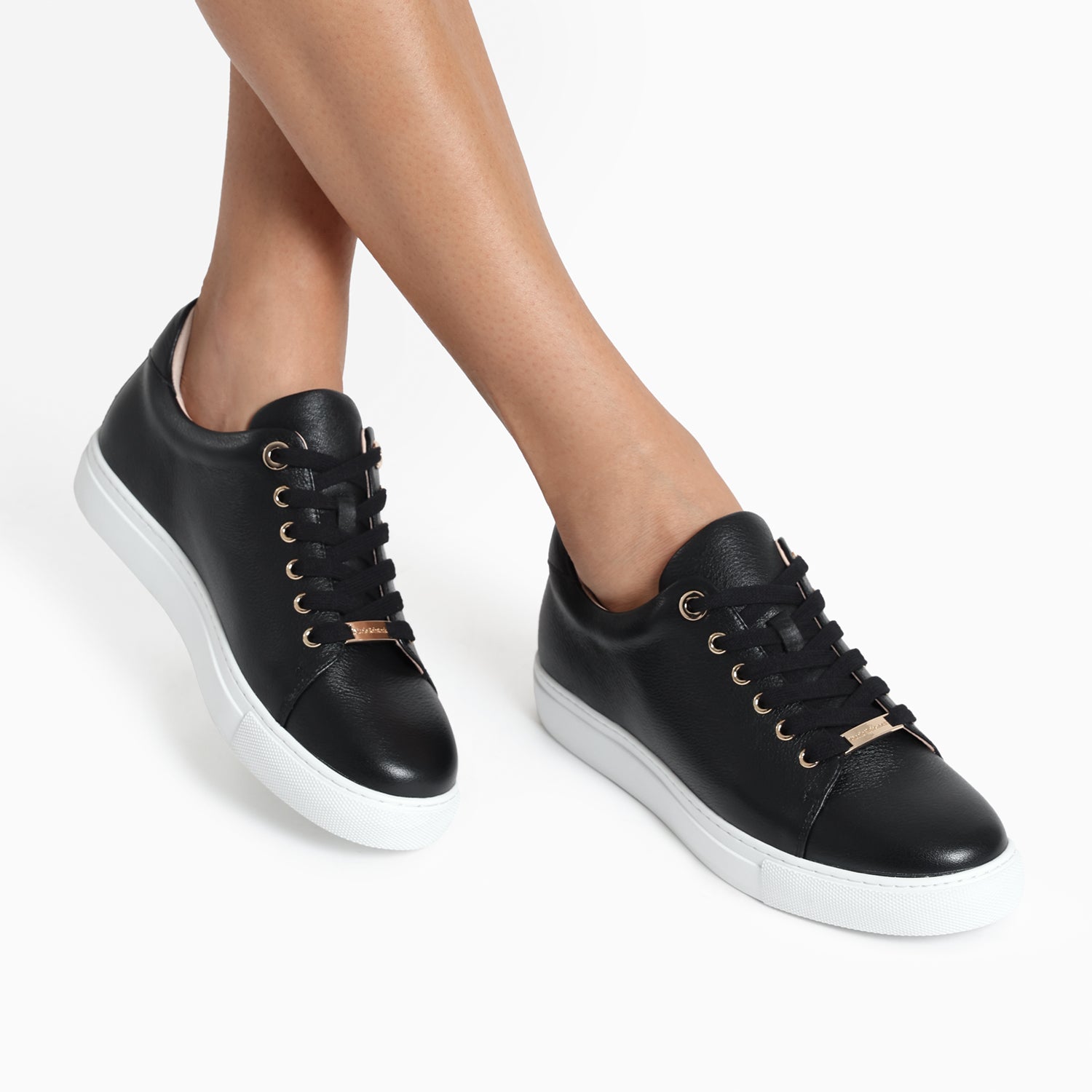 Mace black leather sneaker shown on women's feet.