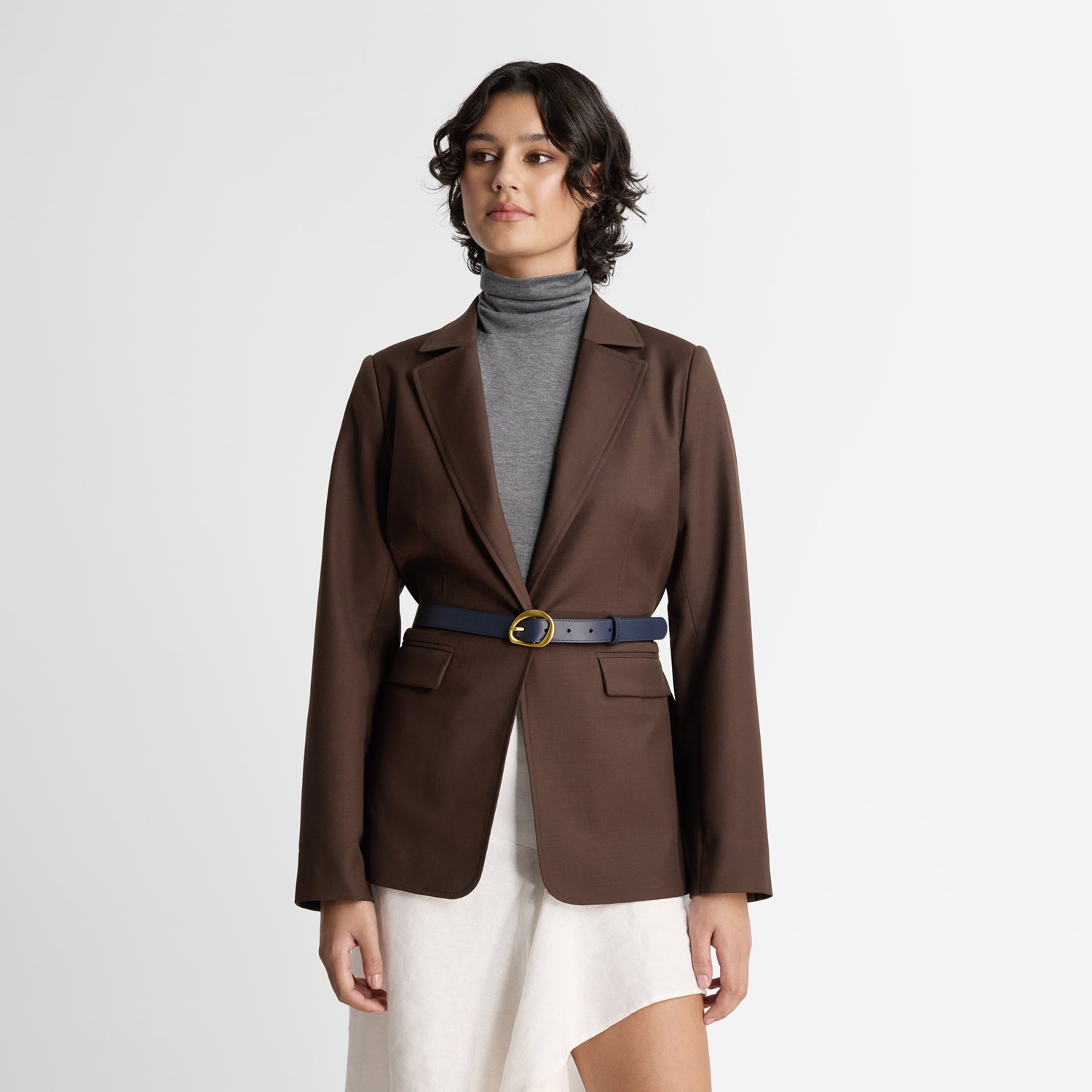 Model wearing Nicole Rebstock's Maple Leather Belt in navy leather with a gold buckle. Molten-like brass finish.