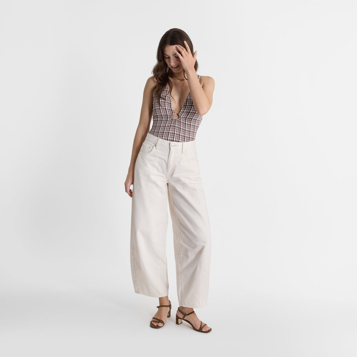 A model wearing Nicole Rebstock Marnie Sandals in brown suede.