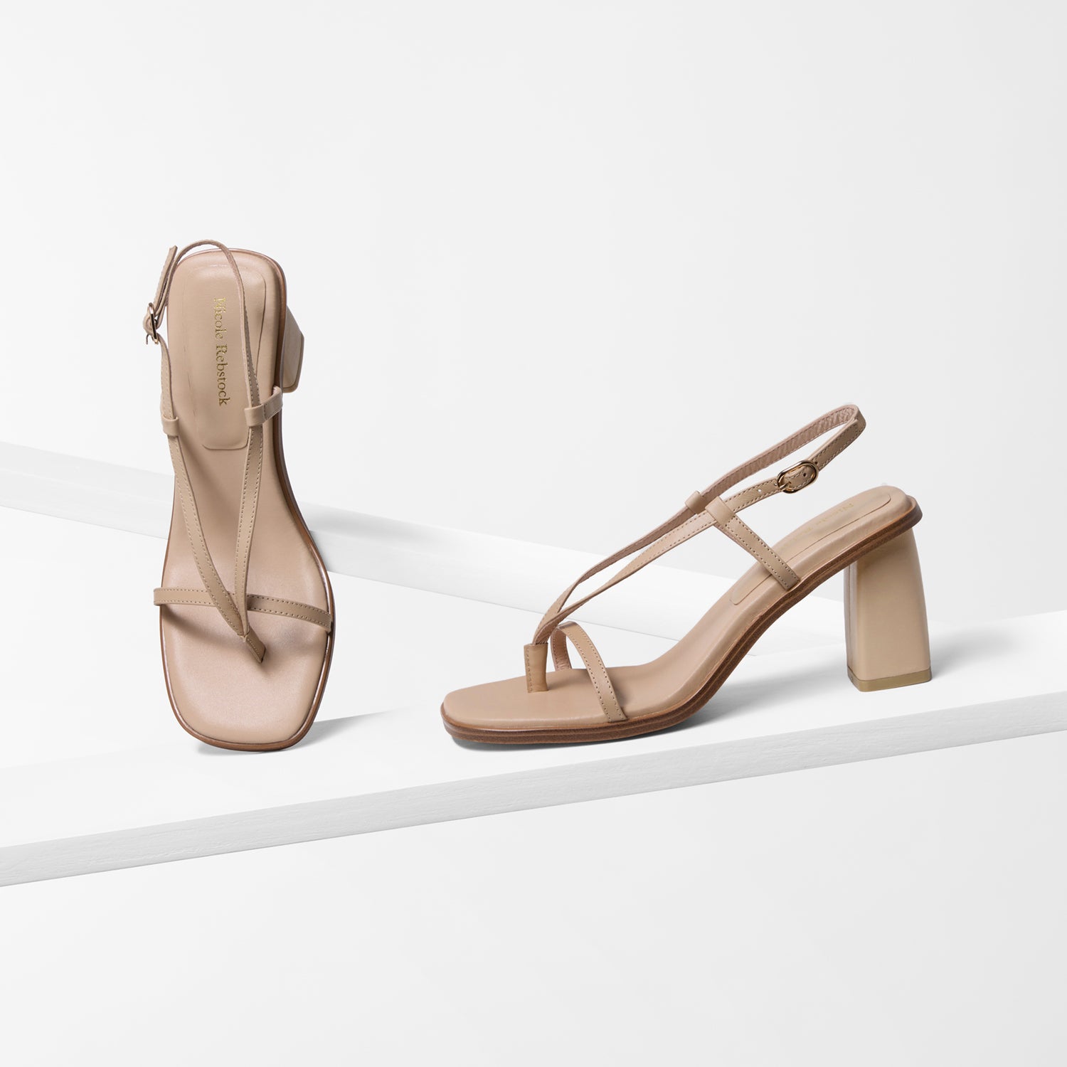 Pair of nude high-heeled sandals on a white background by Nicole Rebstock