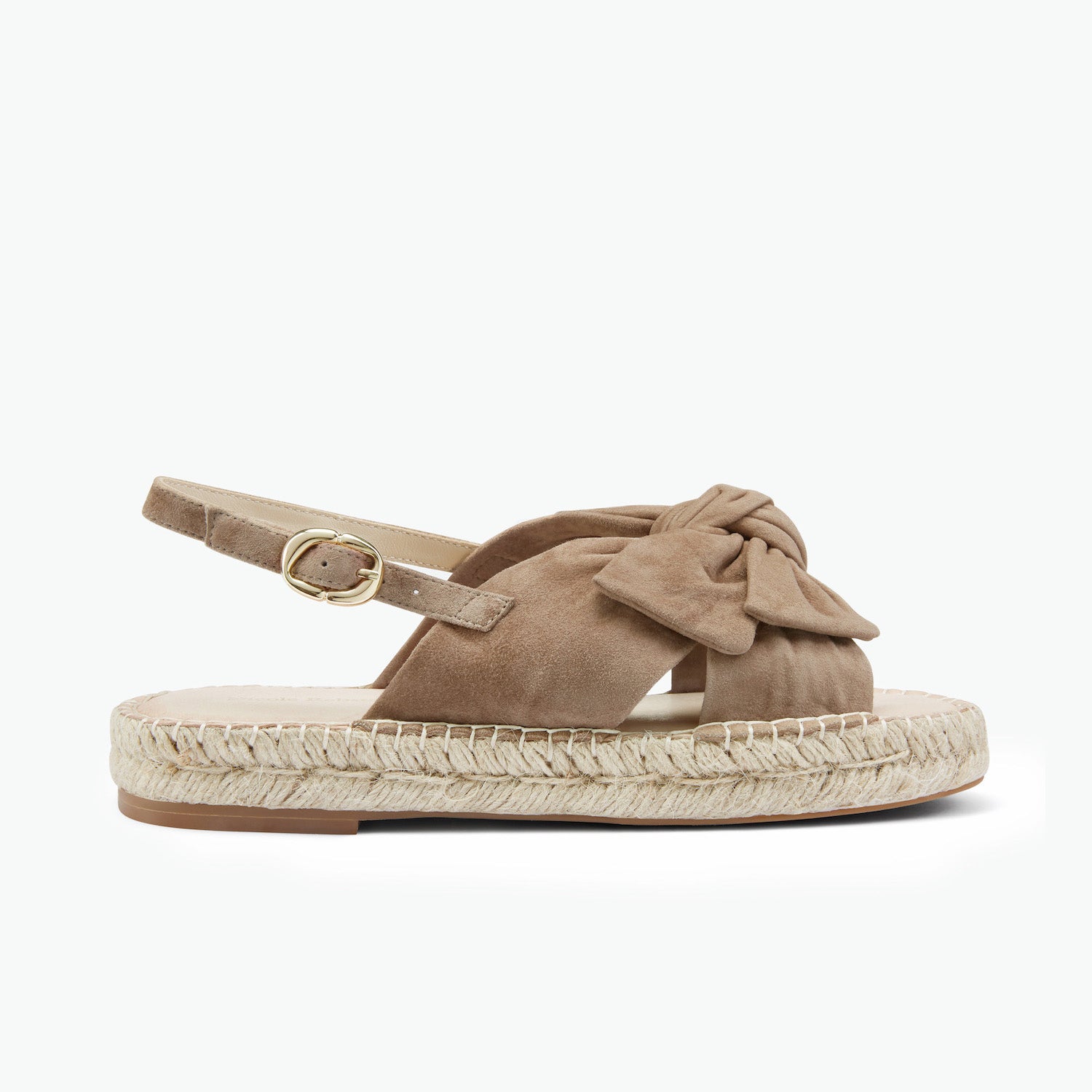 Nude suede sandal with bow detail and gold buckle on a white background.
