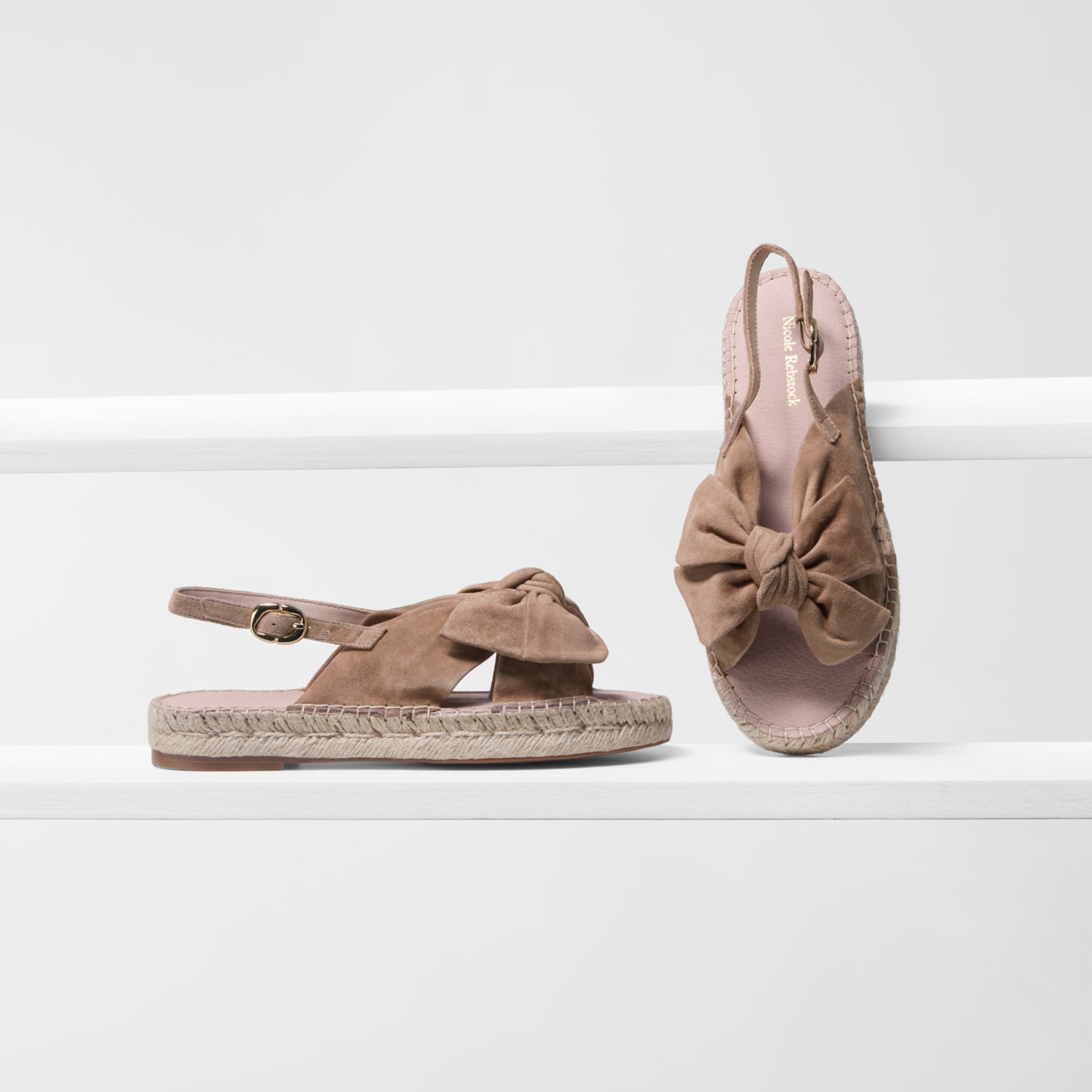 Pair of brown sandals with bow details on a white background