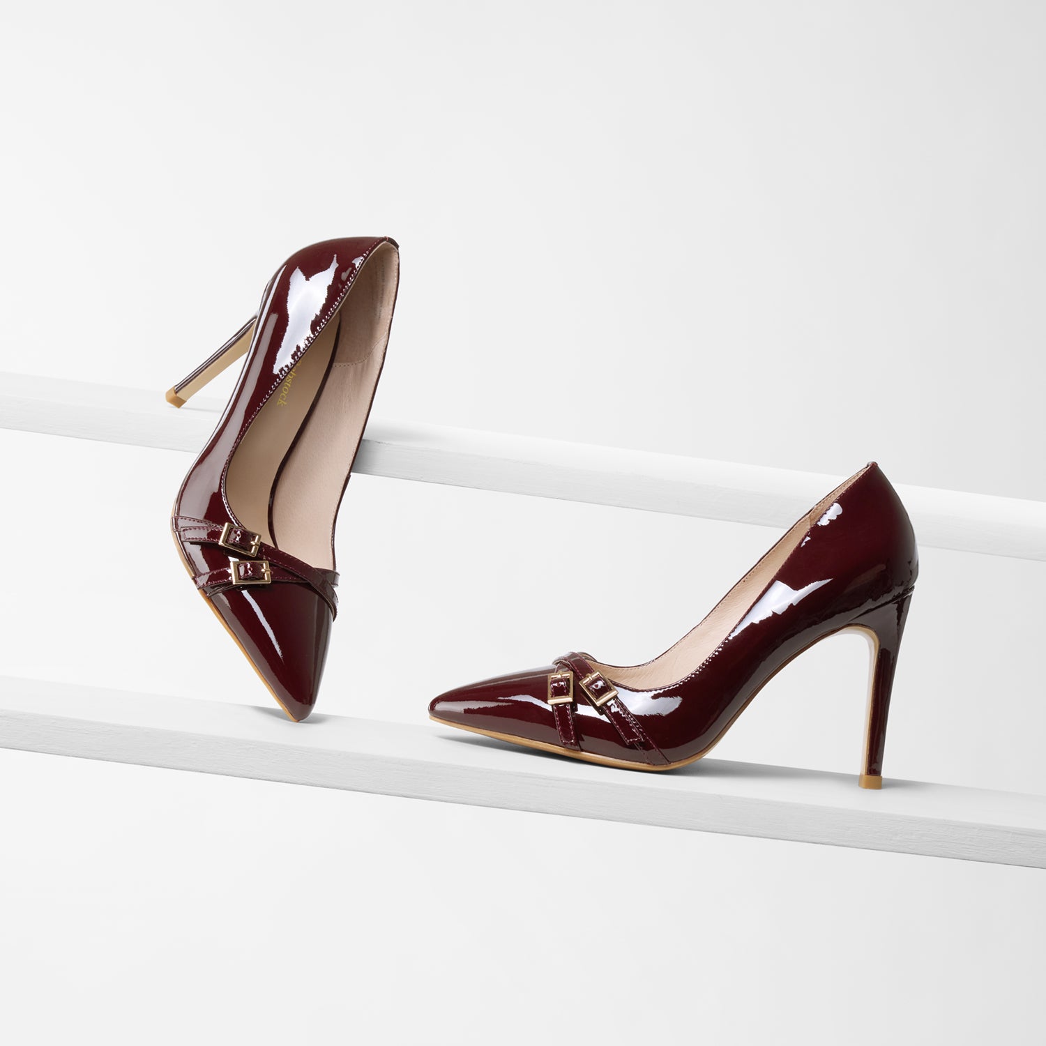 Nash 95mm high pinot noir patent court shoe on planks showing all angles.