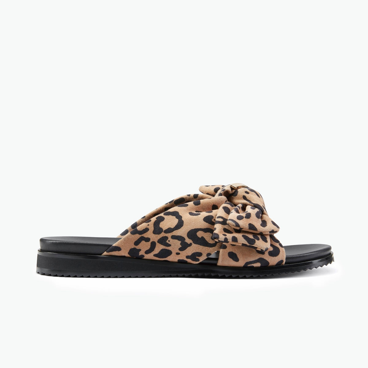 A single women's slide sandal with a black platform sole and a wide, knotted bow strap in a beige and black leopard print, shown against a plain white background.