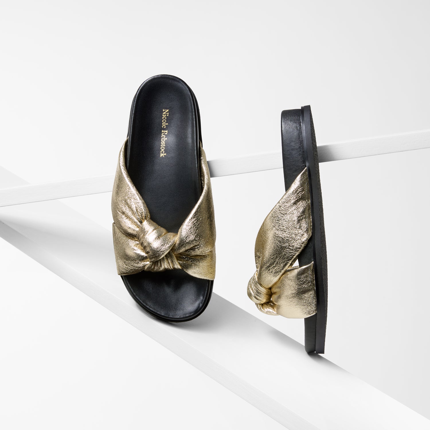 Gold and black sandals on a white background