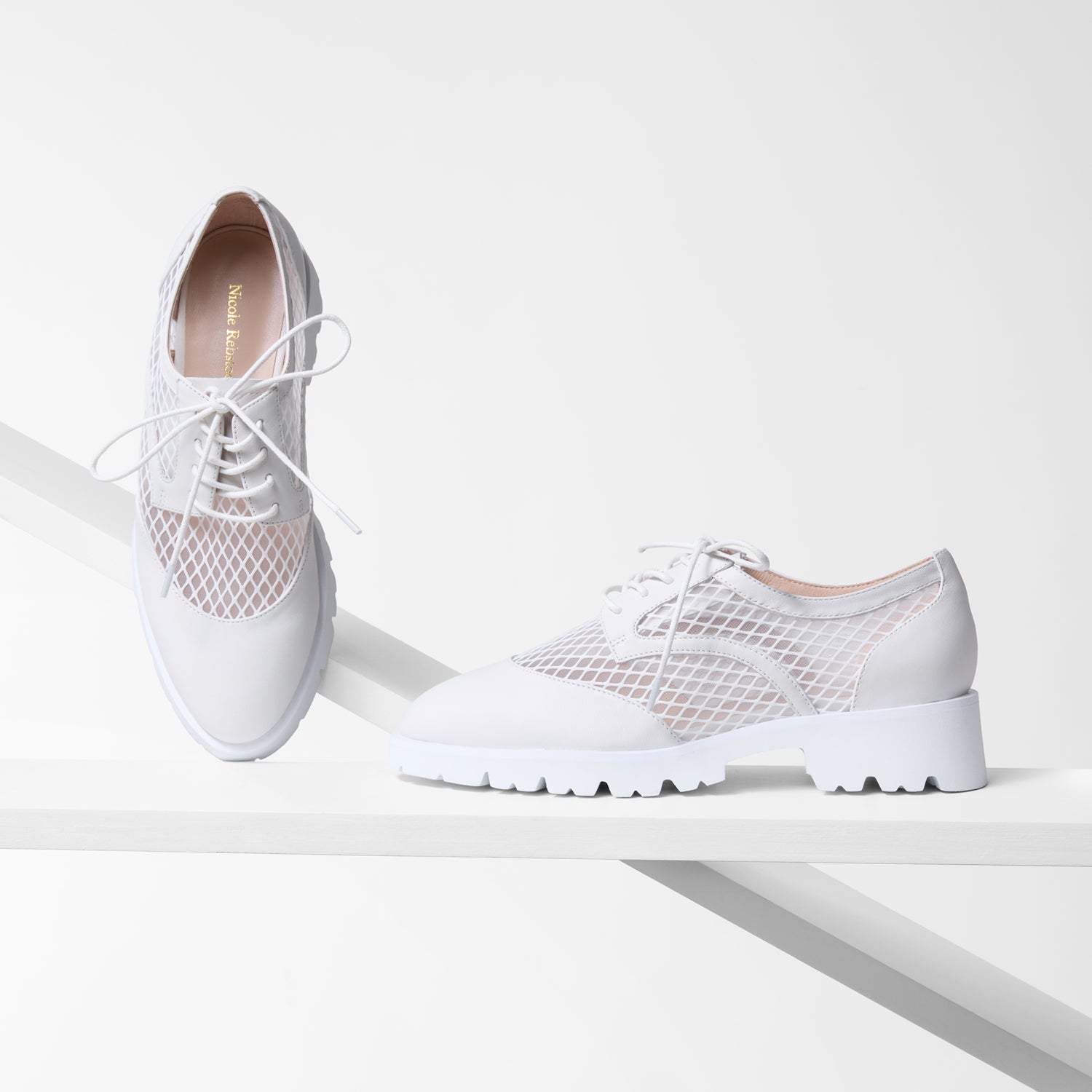White oxfords with leather and mesh design on a white background
