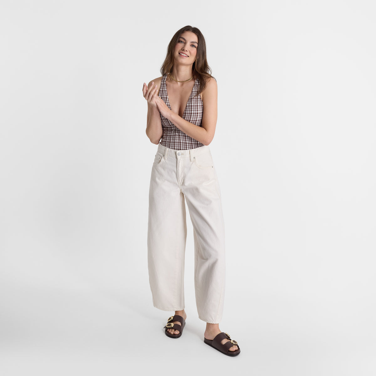 A model wearing Nicole Rebstock's Umi slide sandals in espresso brown leather.