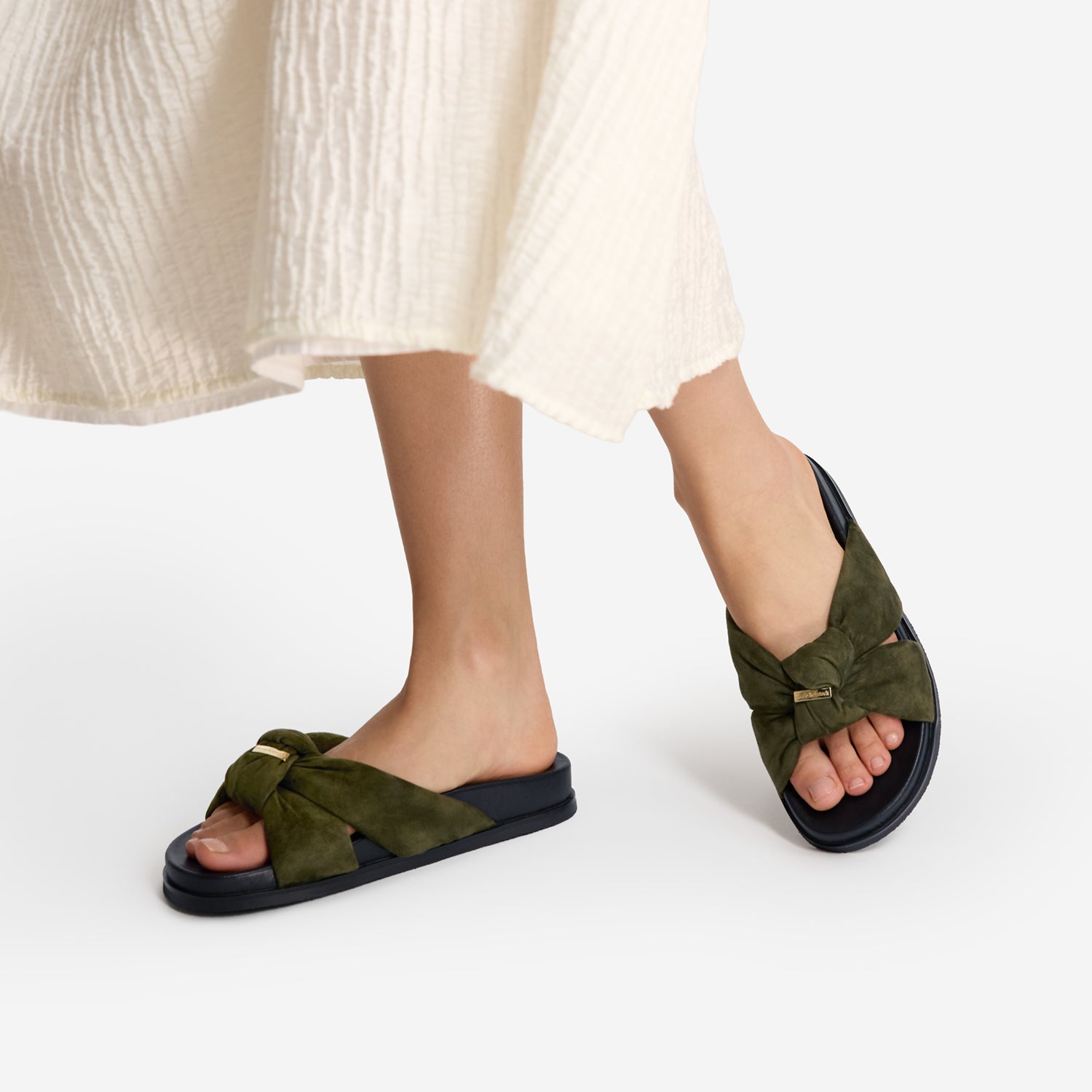 Flat khaki green slides with knot on top. Suede leather with small gold detail.
