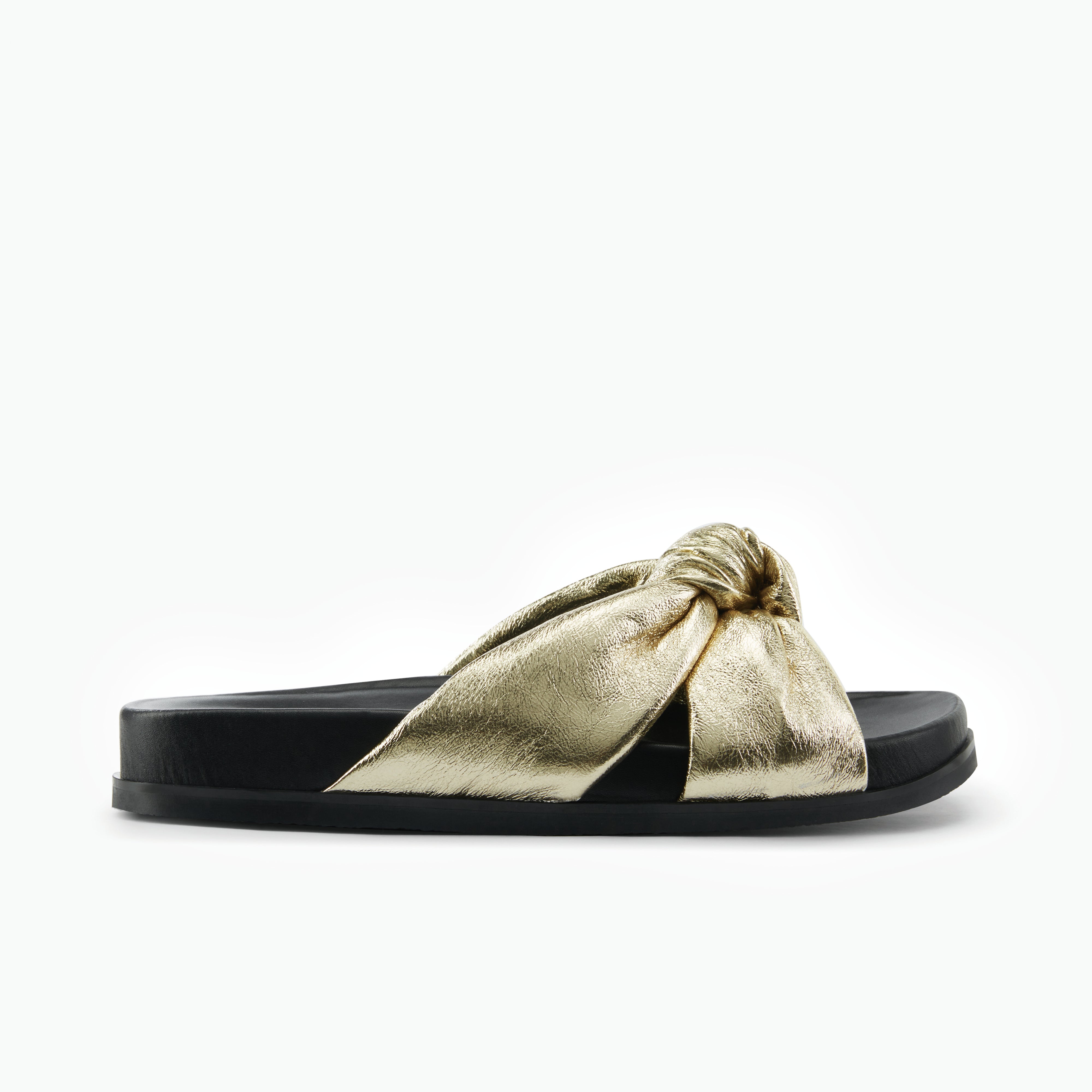 Black slide sandal with a gold knotted bow on a white background