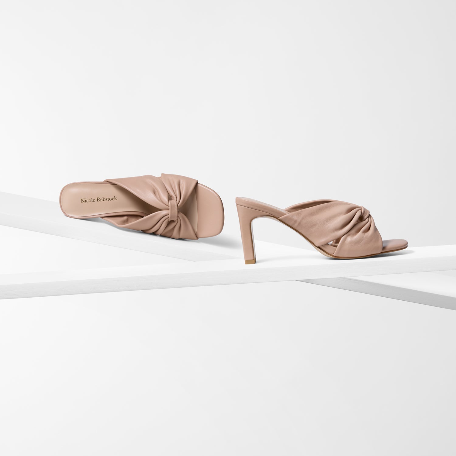 Pair of nude high-heeled shoes on a white background