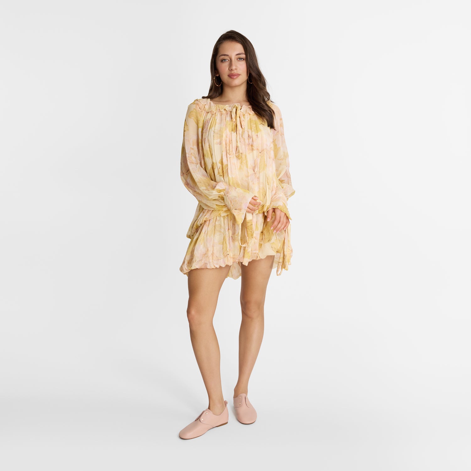 Model wearing Nicole Rebstock Xeno Flat in pastel pink leather with gold heart accents.