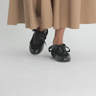 Video of black leather and suede sneakers.